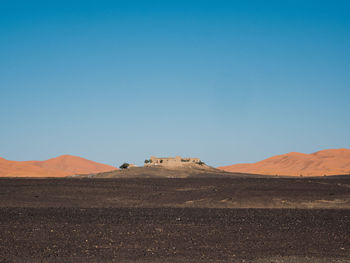 Scenic view of desert against clear blue sky