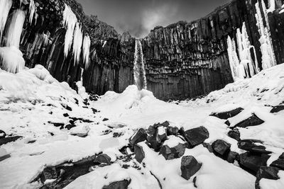 Scenic view of snow covered mountain against cloudy sky
