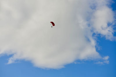 Low angle view of person paragliding against sky