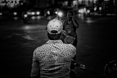 Rear view of man on street at night