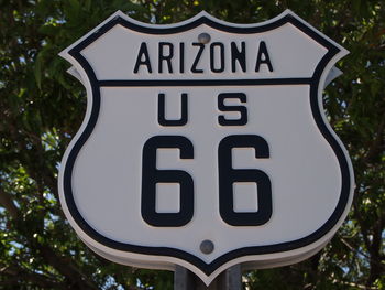 Close-up of road sign against trees