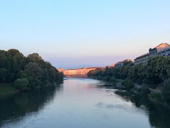 Arch bridge over river against sky during sunset