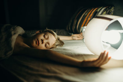 Close-up of young woman sleeping on bed at home