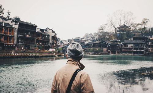 Rear view of man in river against sky