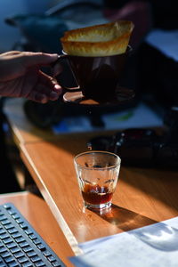 Cropped image of person filtering coffee at desk in office