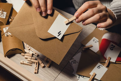 Cropped hands of man holding paper on table