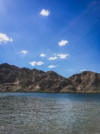 Scenic view of lake by mountains against sky