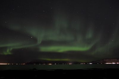 Idyllic view of aurora borealis over river at night