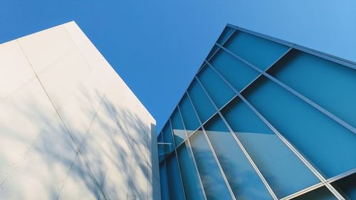 Low angle view of modern building against clear blue sky