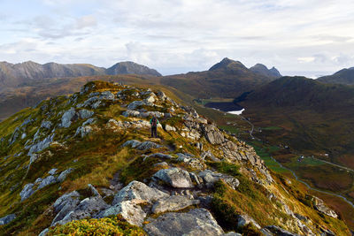 Hiking on top of a mountain on lofoten islands with hiking man and clear sky