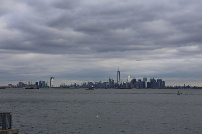 Buildings in city against cloudy sky