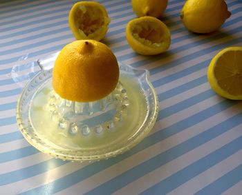 Close-up of lemons and juicer on table