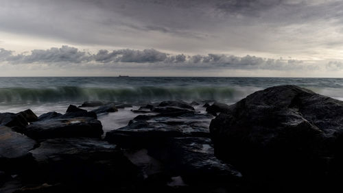 Scenic view of rocks in sea against sky