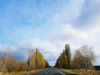 Road amidst trees against sky