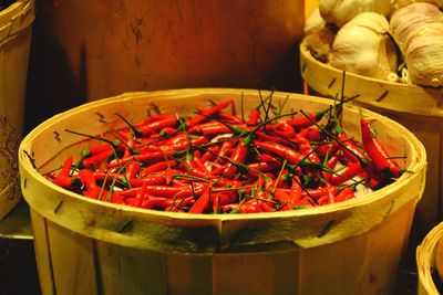 Close-up of red chili peppers in container at shop for sale