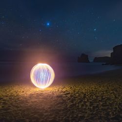 Light painting on beach against sky at night