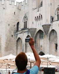 Young man photographing in city