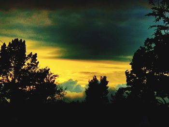 Silhouette of trees against cloudy sky