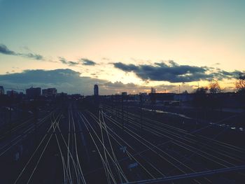 Railroad tracks in city against sky