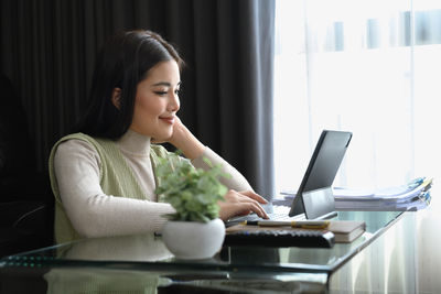 Young woman using mobile phone at home