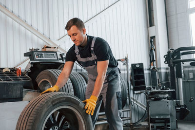  man in uniform is working in the auto service.