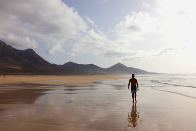 A man walking along the beach