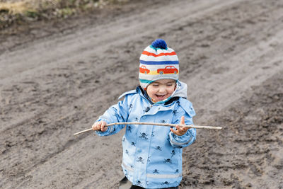 High angle view of cute boy holding stick