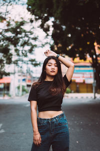 Portrait of beautiful young woman standing in city