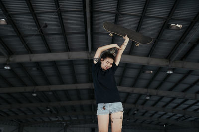 Full length of woman standing by ceiling