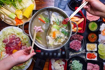 High angle view of hand holding food on table