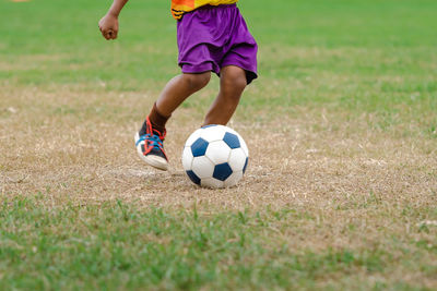 Low section of man playing soccer on field