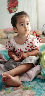 Portrait of cute boy sitting on sofa at home