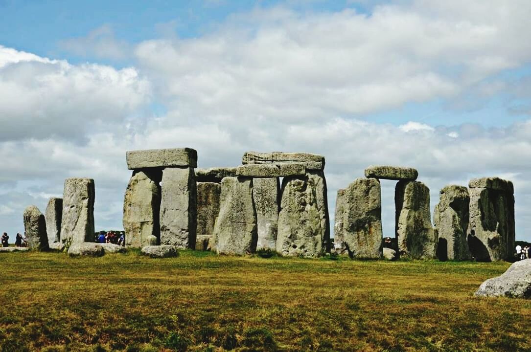 sky, grass, cloud - sky, architecture, built structure, history, old ruin, the past, field, landscape, ancient, cloud, cloudy, tranquility, nature, famous place, tranquil scene, travel destinations, archaeology, old