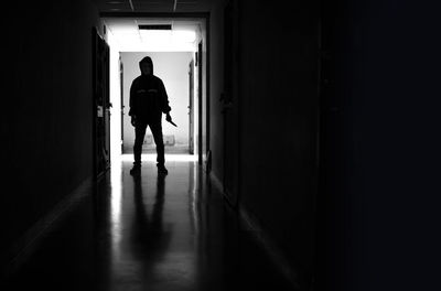 Rear view of silhouette man walking in corridor of building