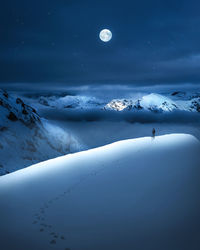 Scenic view of snowcapped mountains against sky at night