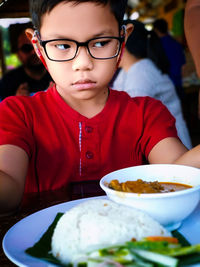 Portrait of boy with ice cream on table
