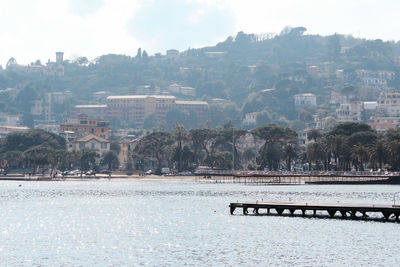 Scenic view of river by town against sky