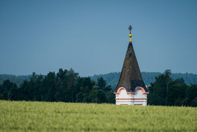 Traditional windmill on field against clear sky