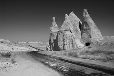 Road amidst rocks against clear sky