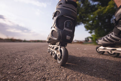 Low section of man rollerskating on road