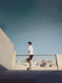 Woman walking against clear sky