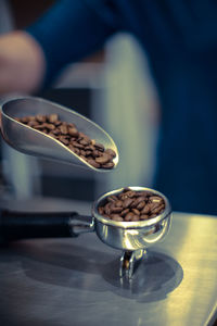 Close-up of roasted coffee beans in serving scoop