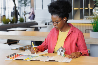 Architect writing in diary at cafe