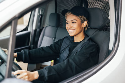 Portrait of smiling young woman sitting in car