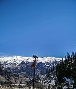 Low angle view of snowcapped mountain against clear blue sky