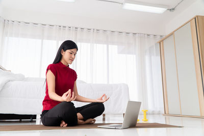 Full length of woman sitting on laptop