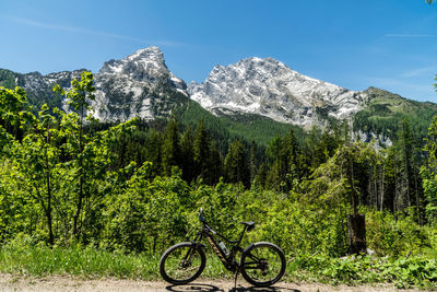 Bicycle parked by tree mountains against sky