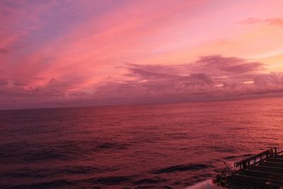 Scenic view of sea against dramatic sky during sunset