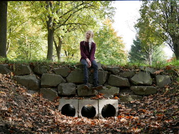 Full length of woman sitting in forest