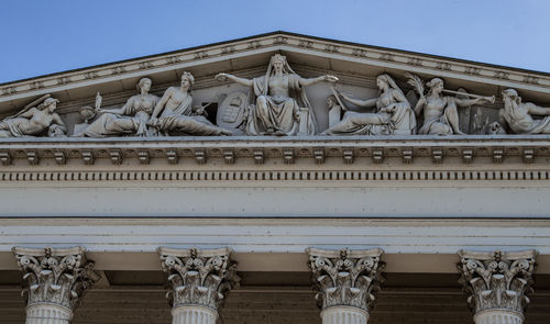 Low angle view of statues on building against sky